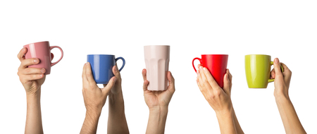 Many different hands holding multi colored cups of coffee on a white background. Female and male hands. Concept of a friendly team, a coffee break, meeting friends, morning in the team. Banner.の写真素材