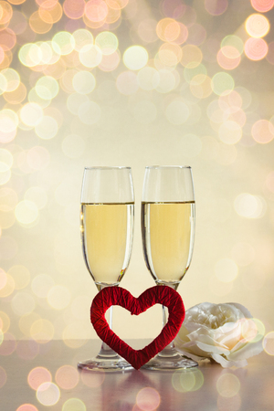 Two glasses with champagne, a hand-made maid and a white rose flower. Bokeh.の写真素材