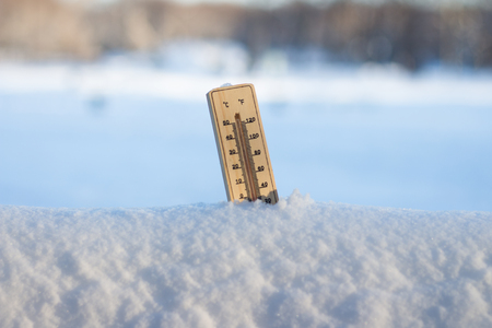 Thermometer in snow in sunny weather. Freezing day. Winter Concept.