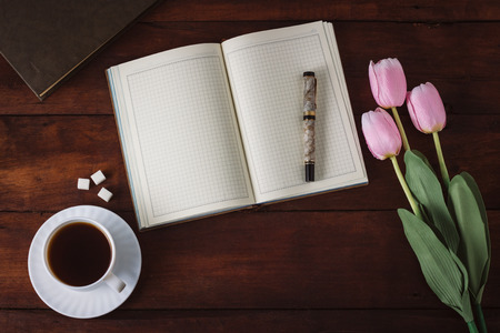 Diary, Cup with Coffee, Tulips, Book on the Dark Wooden Table.の写真素材