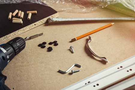 Tools, Furniture parts, Wrapping film, Screws on a sheet of cardboard. Building Furniture Manually, Self-Assembly Furniture.の写真素材