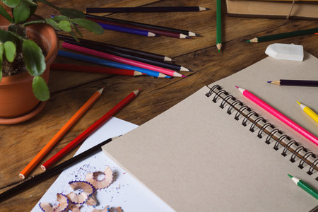 Open Notebook, Blank Paper Sheet, Colored Pencils on the Old Wooden Table.の写真素材