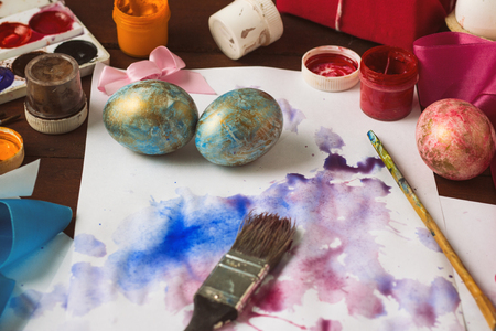 Preprimary painting of Easter Eggs, Brushes, Paints, Eggs on the Dark Wooden Table. Easter concept.の写真素材