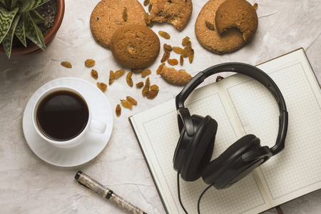 Cup of coffee Diary Cookies Flower in the pot Headphones on a light background. Concept of Education.の写真素材