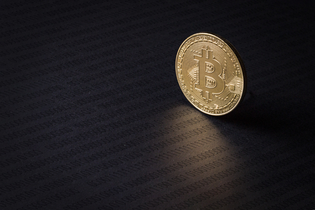 Bitcoin coin on a dark background with a dark computer code. The concept of growth and stability of Crypto currencyの写真素材
