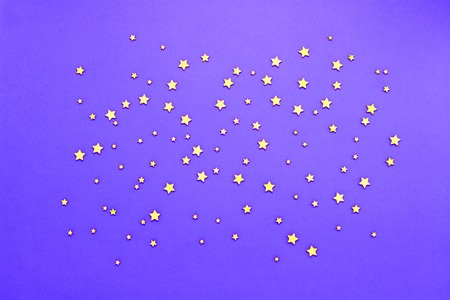 Decorative stars on a lilac background. Concept of the night sky. Can be used as wallpaper or background. Flat lay, top view.の写真素材