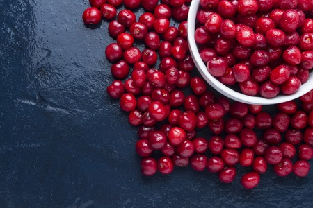 Freshly picked cherry with drops of dew and water in a white bowl. Concept of harvest. Flat lay, top view.の写真素材