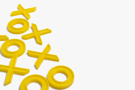 Yellow plastic figures for playing tic-tac-toe on a white background.の写真素材