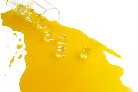 spilled glass of orange juice with ice cubes on a white background. Flat lay, top view.の写真素材