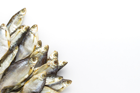 Dried fish lined in the lower left corner on a white background. Flat lay, top view.の写真素材