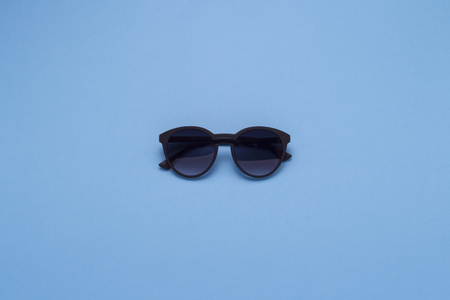 Sunglasses on a blue background. Concept of Travel and Holidays. Flat lay, top view.の写真素材
