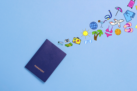 Passport and added icons of the Journey and Rest on the Blue background. Minimalistic style. Concept of Travel and Holidays. Flat lay, top view.の写真素材