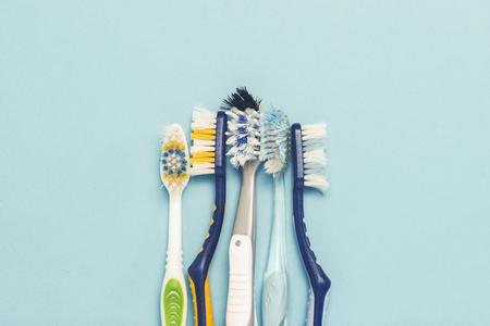 Several different used toothbrushes on a blue background. Toothbrush change concept, oral hygiene, big and friendly family. Flat lay, top viewの写真素材