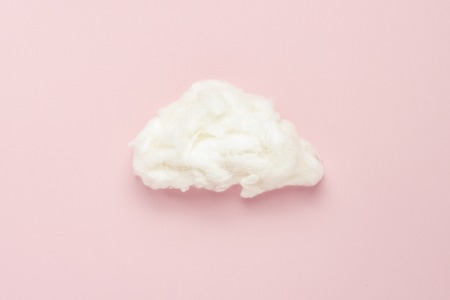 Cloud of cotton wool on a pink background. Concept of rain, rain. Flat lay, top viewの写真素材
