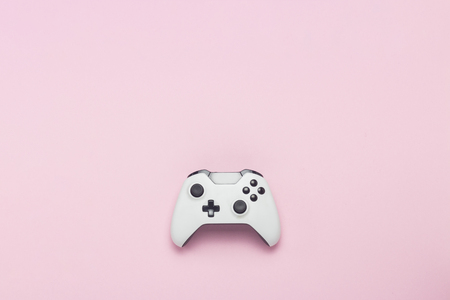 White gamepad on a pink background. Concept game on the console, computer games. Flat lay, top viewの写真素材