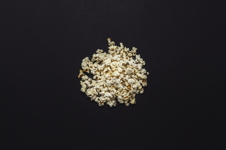 A pile of popcorn on a black background. Flat lay, top viewの写真素材