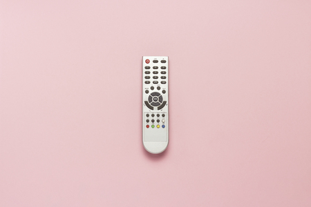 Gray remote control on a pink background. The concept of television, movies, TV shows, sports, day and night. Flat lay, top viewの写真素材