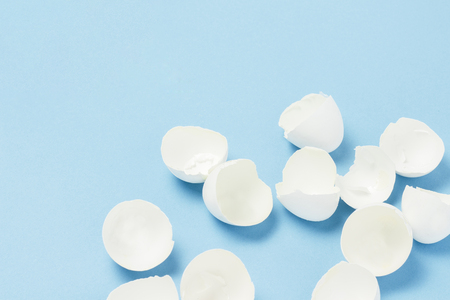 White Shell from broken eggs on a blue background. The concept of birth, cooking, replenishment in the family. Flat lay, top viewの写真素材