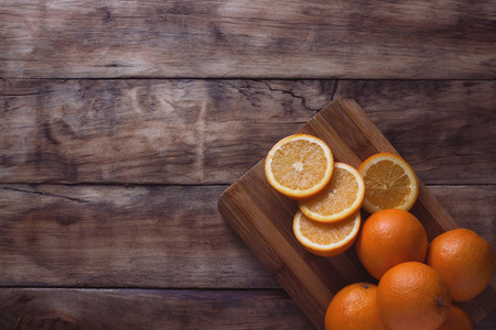 Cut Orange, Slices of Apelsin on the Wooden Board. Dark background. Flat lay, top view.の写真素材