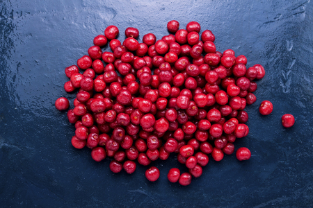 Freshly picked cherries with droplets of dew and water on a wet dark blue background. Concept of harvest. Flat lay, top view.の写真素材