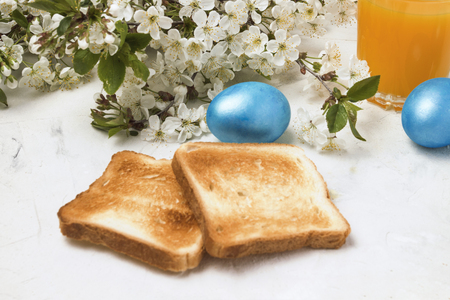 Easter Blue Eggs, Toasts and Orange Juice on a Light Backgroundの写真素材