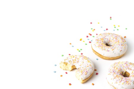 Fresh tasty donuts and sweet multicolored decorative candy on a white background. Bakery concept, fresh pastries, delicious breakfastの写真素材