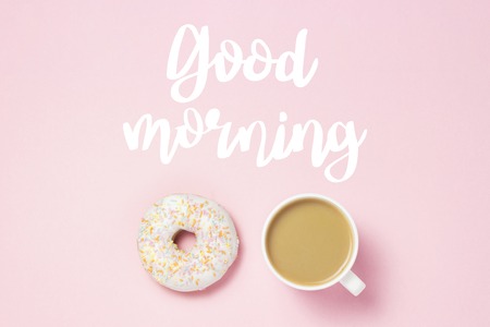 Cup with coffee or tea, Fresh tasty sweet donut on a pink background. Added text Good morning. Bakery concept, fresh pastries, delicious breakfast, fast food, coffee shop. Flat lay, top viewの写真素材