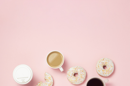 Cups with coffee or tea, Fresh tasty sweet donuts on a pink background. Fast food concept, bakery, breakfast, sweets, coffee shop. Flat lay, top view, copy spaceの写真素材