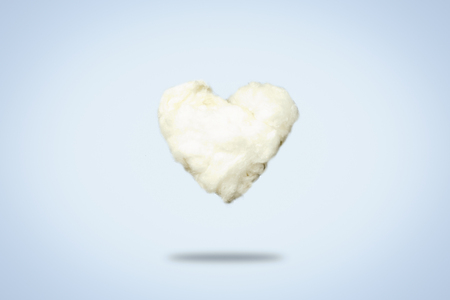 Cloud of cotton wool in the shape of a heart on a blue background. Love Concept, Valentine's Dayの写真素材