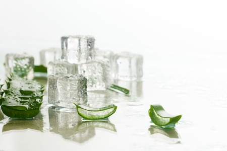 Aloe leaf and ice cubes on a light background. Refreshing and cooling for skin, anti-thirst drinkの写真素材
