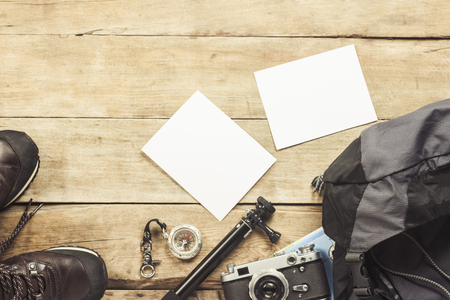 Boots, backpack, compass and other camping gear on a wooden background. The concept of hiking in the mountains or the forest, tourism, tent rest, camp. Flat lay, top viewの写真素材