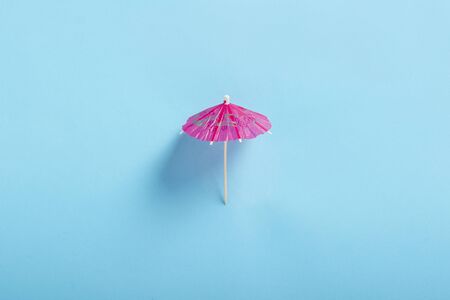 Decorative umbrella for a cocktail on a blue background. Flat lay, top view.の写真素材