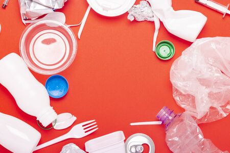 Plastic and tin waste collection on a red background. Concept stop plastic, recycling, separate...