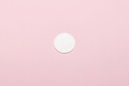 Cotton hygienic make-up disk on a pink background. Makeup and hygiene concept. Flat lay, top view.の写真素材