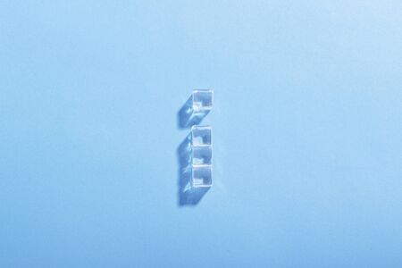 Ice cubes on a blue background. The concept of heat, cooling. Natural light. Flat lay, top view.の写真素材