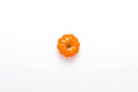 Decorative pumpkin on a white background. Halloween concept, harvest, autumn. Flat lay, top view.の写真素材