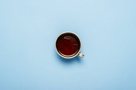 Metal cup with hot tea on a blue background. Flat lay, top view.の写真素材