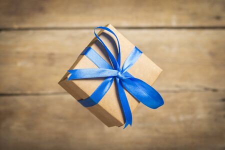 Flying gift box on a wooden background. Holiday concept, christmas. Levitation.の写真素材