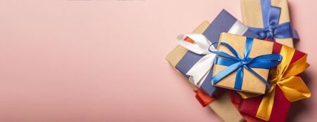 Stack of gifts on a pink background. Gift concept for a loved one, holiday, Christmas. Banner. Flat...