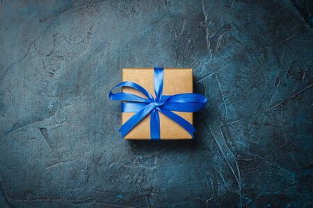 Gift box on a dark blue stone background. Gift concept for a loved one. Flat lay, top view.の写真素材