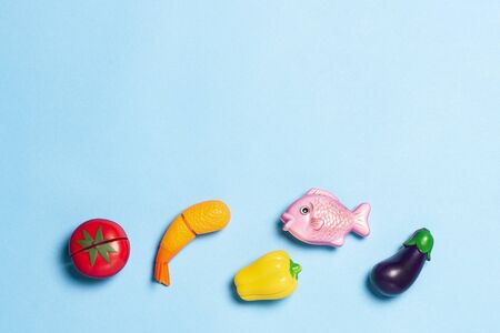 Children's educational toys in the form of food on a blue background. Child development concept, kitchen for children. Artificial food, proper nutrition. Flat lay, top view.の写真素材