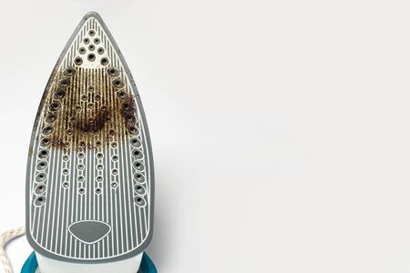 Dirty surface Iron for ironing things on a white isolated background. Concept breakdown or problem, laundry, sewing studio, housework.の写真素材