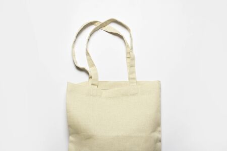 Bright linen bag for shopping on a white background. Eco material. Shopping concept, place for . Flat lay, top view.の写真素材