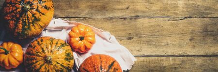 Pumpkins on a wooden background. Harvest concept, autumn, Halloween eve. Banner. Flat lay, top view.