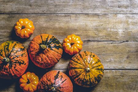 Pumpkins on a wooden background. Harvest concept, autumn, Halloween eve. Banner. Flat lay, top view.の写真素材