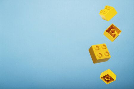 Details of a toy constructor fly in the air against a blue background. Levitation. Logic concept, kids toys. Flat lay, top view.の写真素材