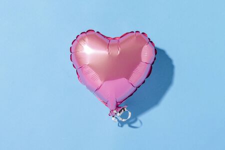 Air balloon heart shape on a blue background. Natural light. Banner. Concept love, wedding, photo zone. Flat lay, top view.の写真素材