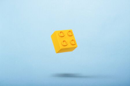 Detail of a toy constructor flying in the air against a blue background. Levitation. Logic concept, kids toys. Flat lay, top view .の写真素材