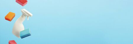 Flying in the air White bottle with spray and sponges for cleaning and washing on a blue isolated...