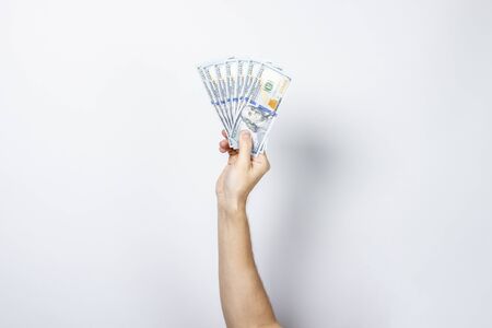 Female hand holds money on a white isolated background. Concept is rich, wealth, buy, pay, tax....